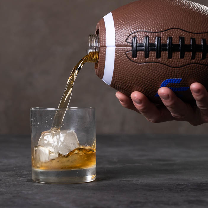 Pouring out whiskey from the football flask
