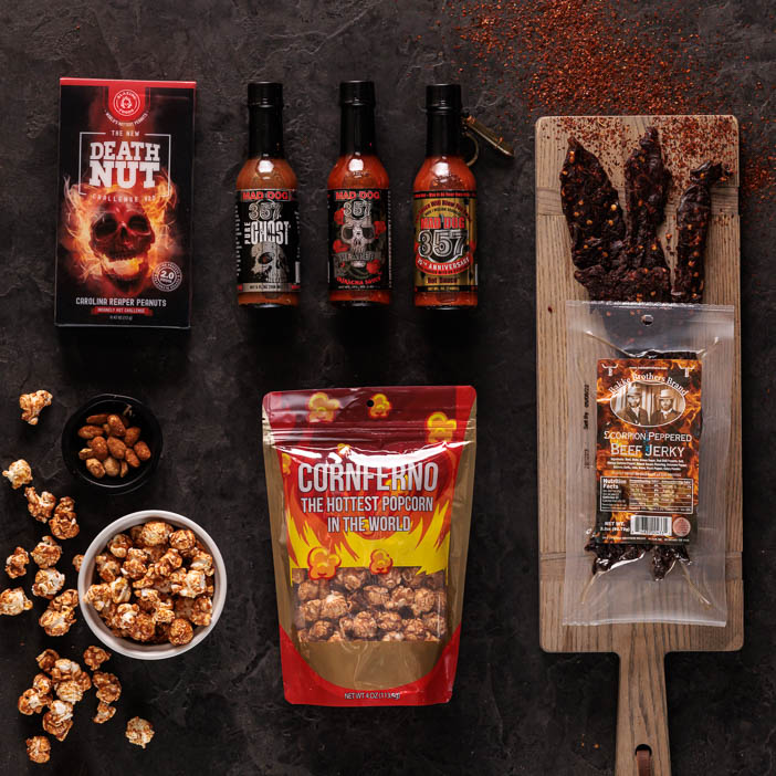 Spicy popcorn, nuts, sauces, and jerky overhead view for men's snack gift.