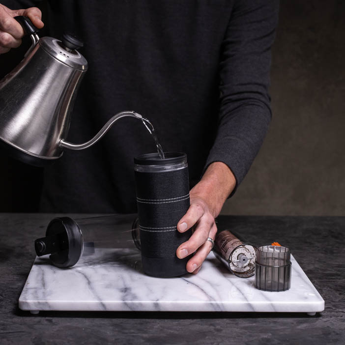 man pouring boiling water into press for a great men's drink gift.