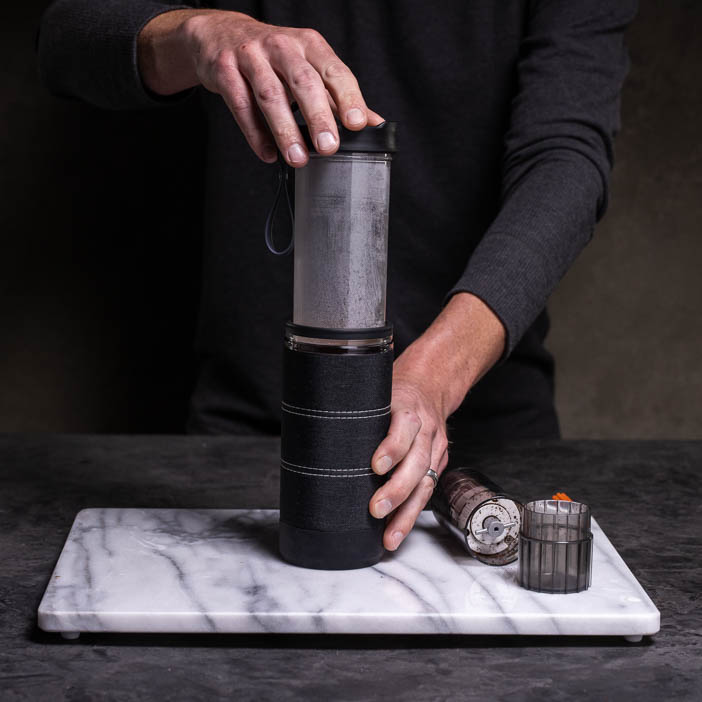 Man inserting press into tumbler for a great men's drink gift.