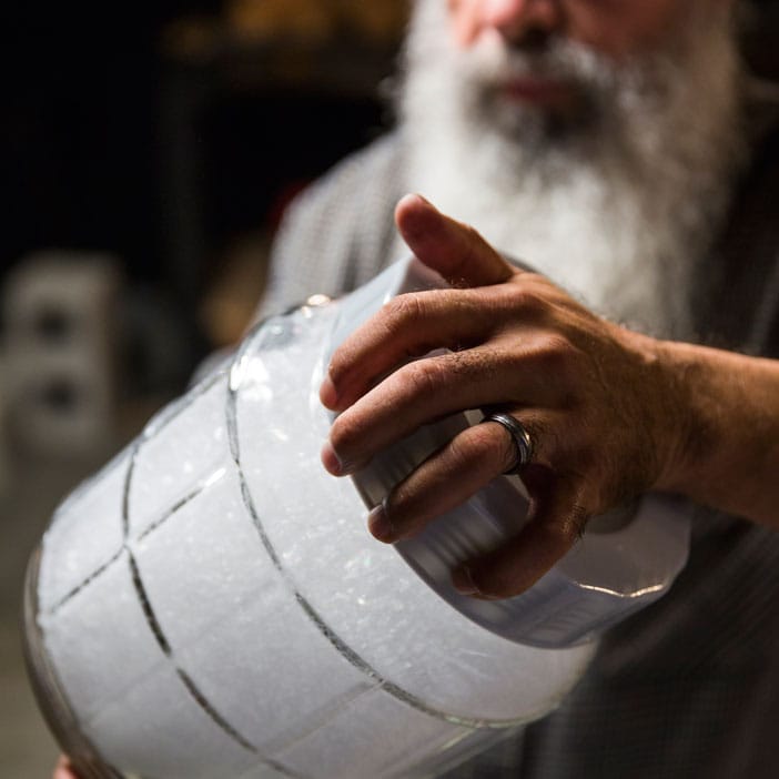 Man with beard holding jar for men's DIY gift.