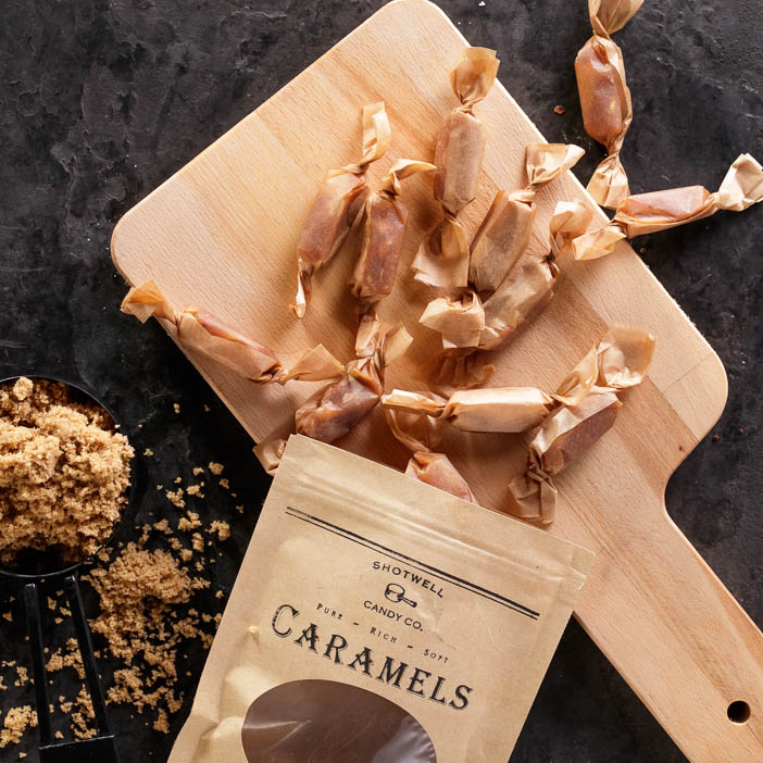 Boozy Caramels spilling onto a cutting board for a great men's snack gift.