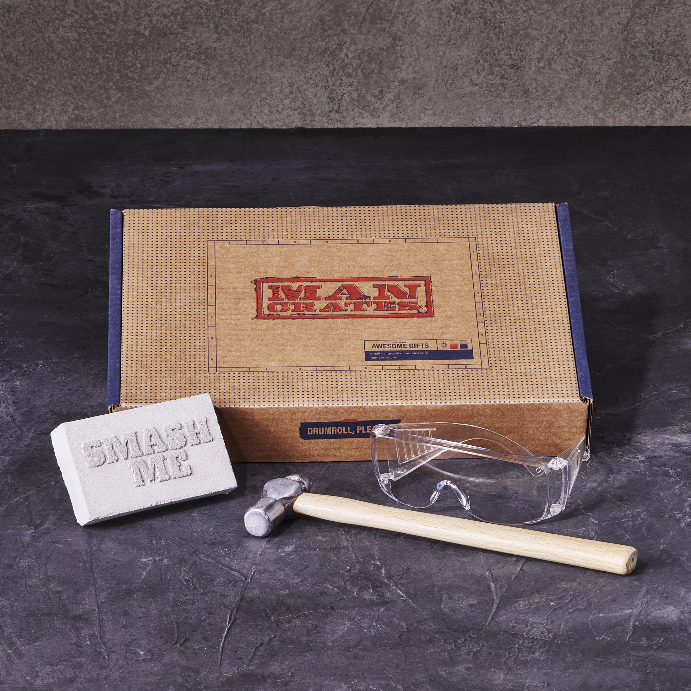 Smash & Grab Gift Card box components include hammer, safety goggles, and concrete brick.