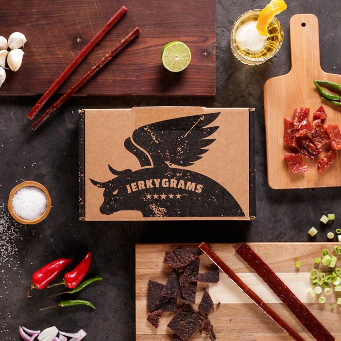 Jerkygram box surrounded by delicious meat is a great snack gift for men.
