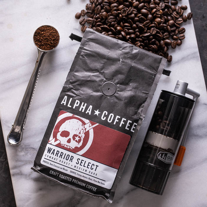 Overhead view of spoon, grinder, and bag of coffee beans for a great men's drink gift.
