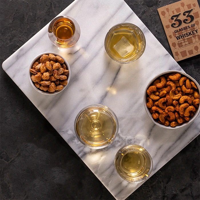 Whiskey nuts in bowls with glasses for a great men's whiskey gift.